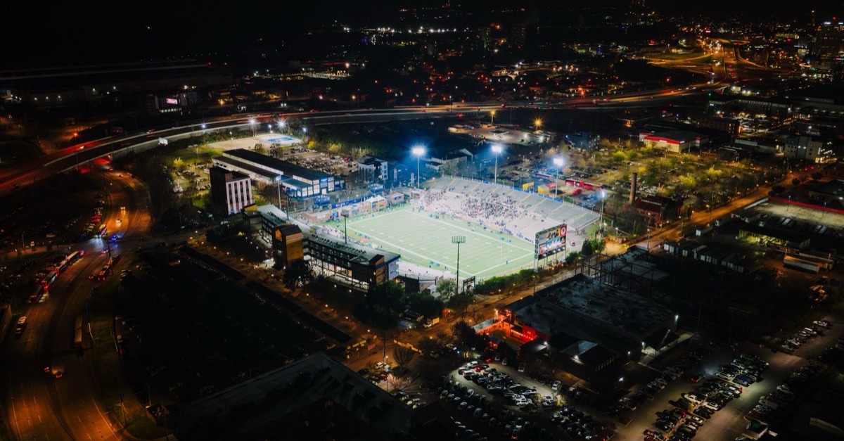 Aerial night view of a lit football stadium surrounded by city streets in Chattanooga, Tennessee